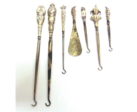 SIX SILVER MOUNTED STEEL BOOT AND BUTTON HOOKS AND A SHOE HORN, INCLUDING MR PUNCH AND TOBY comprising; two WITH shaped oval 