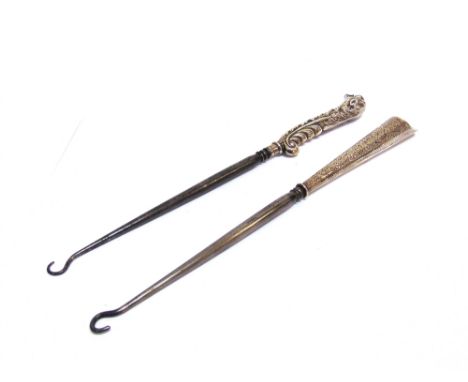 TWO LATE VICTORIAN SILVER MOUNTED STEEL BUTTON OR BOOT HOOKS, ONE WITH A DOG'S HEAD HANDLE  and with scrolling leaves on a ma
