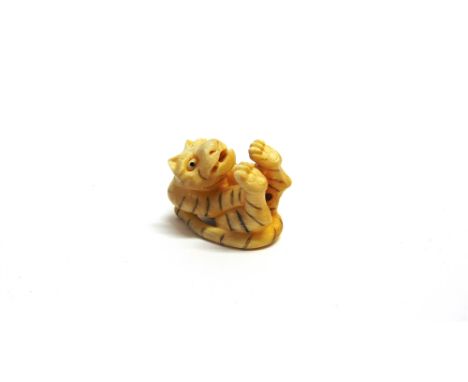 A CARVED IVORY NETSUKE  probably Meiji, modelled as a tiger, signed, 4.5cm long