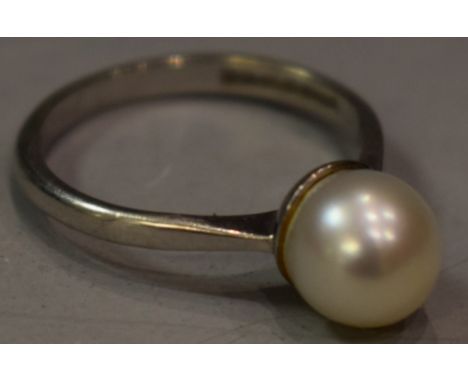 A pearl solitaire ring, creamy white cultured pearl, approx 7.9mm diameter, 18ct white gold shank, size N/O, Birmingham 1967,