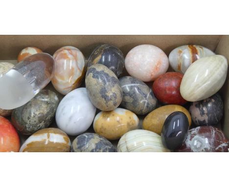 A collection of polished hardstone specimen eggs, to include agate and onyx; together with an art glass paperweightAll with s