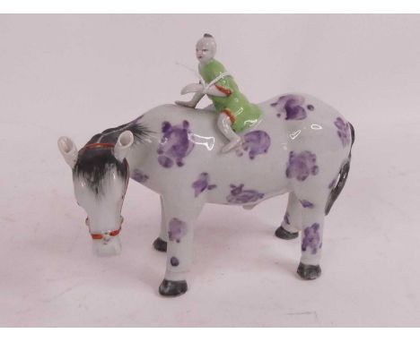 A Chinese porcelain figure of a boy seated on a mule, height 16cmSome light scratching to the enamel and bubbling to the gree