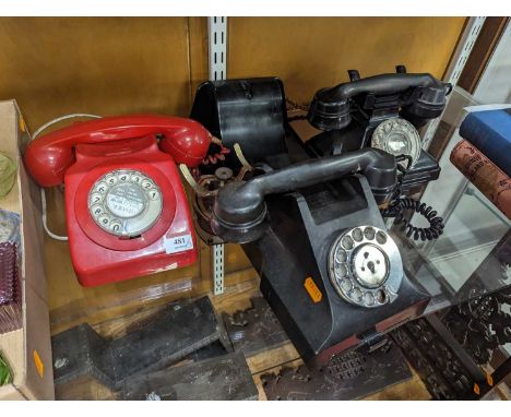 A collection of three vintage bakelite and plastic rotary telephones 