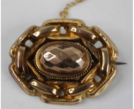 A Victorian yellow metal boss shape oval brooch, with chain link border, having steel pin and safety chain, unmarked but test