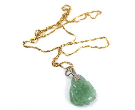A Chinese carved celadon jade pendant as a Buddha, having slice-cut polished back, h.1.8cm, with white metal bale, 2.1g, sold