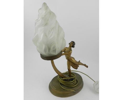 In the Art Deco style, a table lamp in the form of lady, raised on an oval base, having glass flame shaped shade. H.40cm 