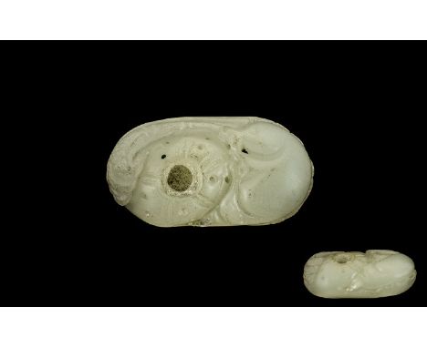 A Chinese Carved Mutton Fat Jade Pebble worked with an exotic feature. Approx 3 by 1.5 inches.