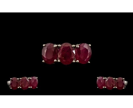 Ruby Three Stone Ring, a trilogy of rubies of good colour, totalling 5.5cts, set in a row, in silver; size N