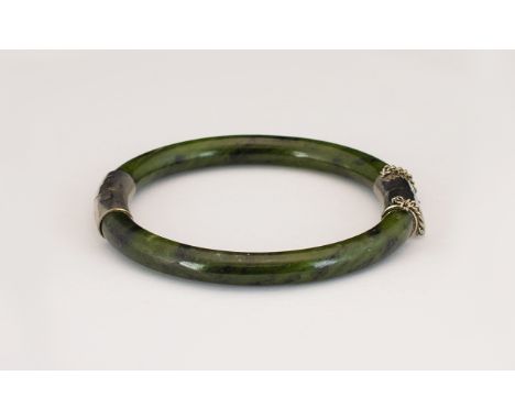 A Hard Stone Jadeite hinged Bangle with  white metal mounts.