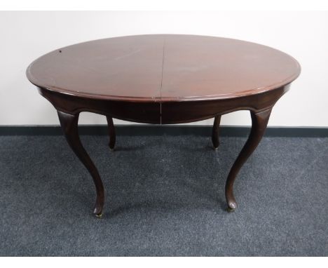 An oval mahogany extending dining table on cabriole legs, with two leaves, together with a set of eight mahogany ladder back 