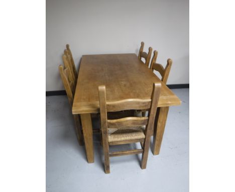 A pine farmhouse kitchen table, together with a set of five pine rush seated ladder back chairs 