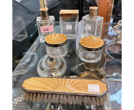 A pair of art deco silver mounted scent bottles, three matching jars and a clothes brush, all decorated in champagne enamel, 