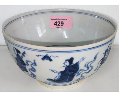 A Chinese ceramic bowl in blue and white decorated with a ring of characters to the outside and deity to the interior with ma