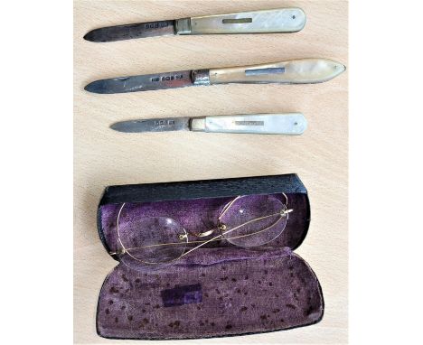 Three hallmarked silver and mother-of-pearl fruit knives; a gilt pair of vintage spectacles 