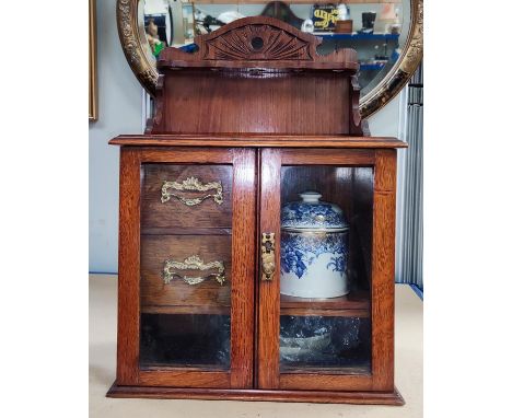 Late 19th/early 20th century smoking cabinet with tobacco jar, glazed doors and pipe rack above