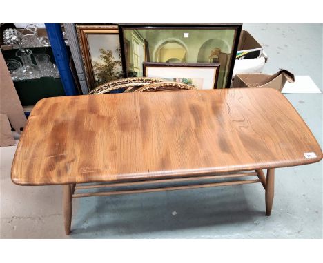 An Ercol light wood coffee table with shaped rectangular top and rail shelf under 