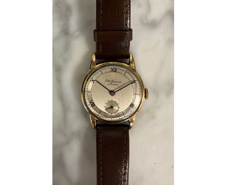 A 1950s J W Benson 9ct gold cased wristwatch, 30mm diameter case, polished and brushed silver dial, Alternating black Roman n