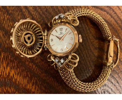 Omega - a 1950s 18ct gold diamond and ruby inset concealed dial cocktail watch, the hinge cover set with seven round old bril