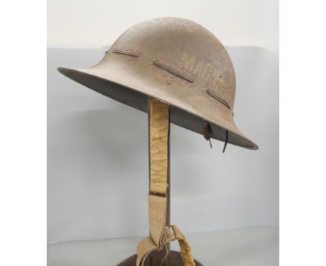 A WWII helmet inscribed 'MAGNA' - Military Aid Good Neighbours Association 