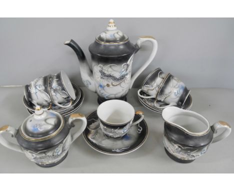 A Chinese tea service comprising of tea pot, four cups and saucers, milk jug and sugar bowl, with Geisha head to base of cups