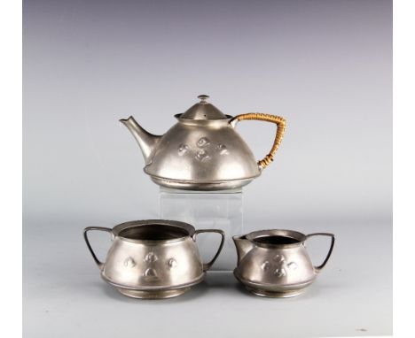 An Arts and Crafts pewter three piece tea service designed by Archibald Knox, probably for Liberty & Co, of squat from and de