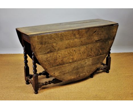 An 18th century style oak gate leg table, on barley twist and block legs, 75cm H x 133cm W x 174cm D