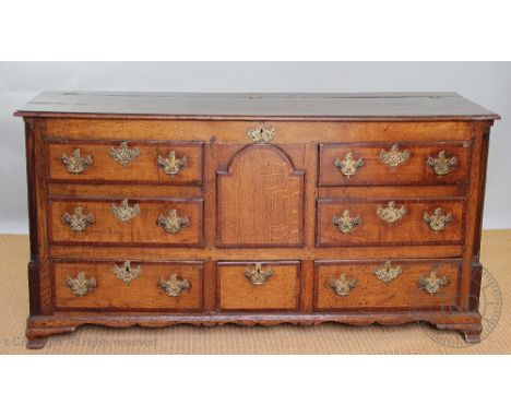 A George III oak and mahogany crossbanded mule chest, with hinged top above four dummy drawers, a central panelled arch and t