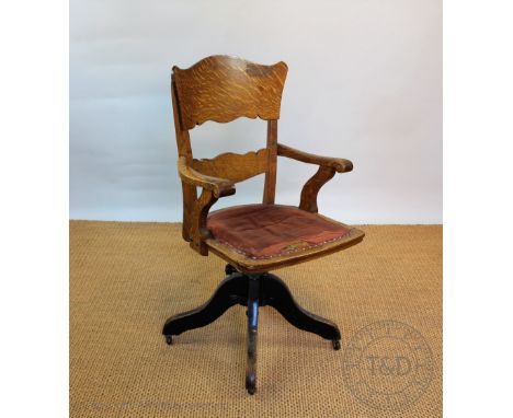 A near pair of Edwardian oak swivel desk chairs, vintage style, with shaped panelled backs and upholstered seats, on adjustab
