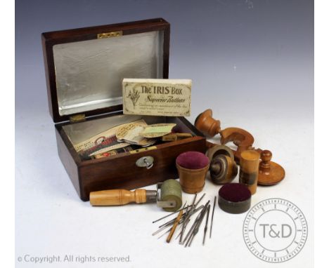 A collection of 19th century and later treen sewing tools, pin cushions and boxes, to include a Mauchline Ware pin cushion ta