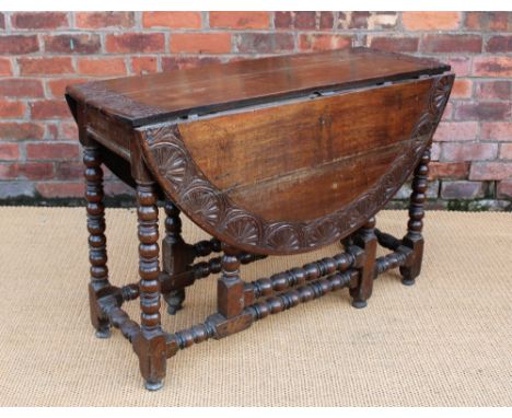 An 18th century and later carved oak gate leg table, on turned and block legs, 76cm H x 115cm Diameter