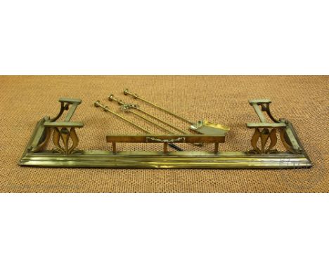 An Art Nouveau style brass fender, decorated with flowers, 132cm wide, with three near matching fire tools (4)