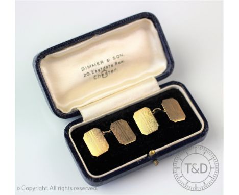 A pair of 9ct yellow gold cufflinks, Birmingham 1920, of canted rectangular form, with engine turned decoration and chain lin