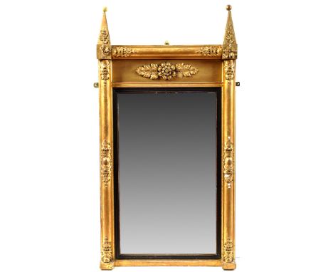 *A Regency giltwood wall mirror, the rectangular plate within ebonised reeded slip, the frame decorated with scrolls, leaf ca