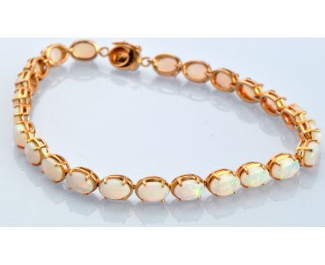 An opal bracelet, the twenty-four oval opal cabochons claw set in yellow metal mounts, stamped '14K' to clasp, 17cms long.