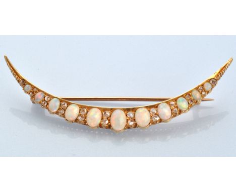 An early 20th Century opal and diamond crescent-shaped brooch, set with eleven graduated oval cabochon opals separated by pai