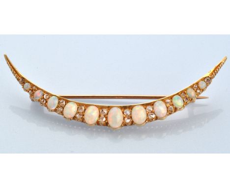 An early 20th Century opal and diamond crescent-shaped brooch, set with eleven graduated oval cabochon opals separated by pai