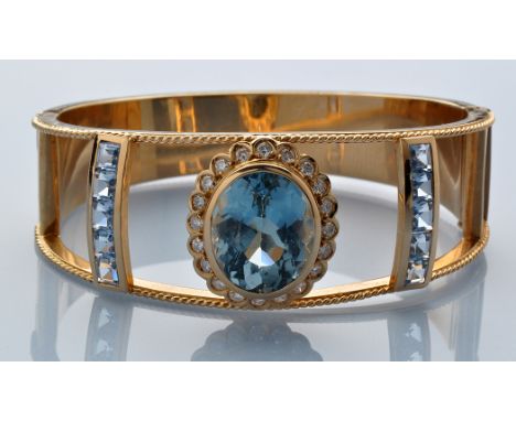 A paraiba tourmaline, diamond and synthetic blue spinel bangle, the oval facet cut paraiba tourmaline measuring 16.4 x 13.4 x