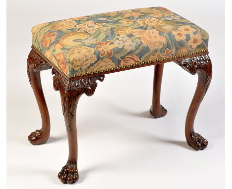 A George III style rectangular mahogany stool, the floral tapestry covered seat raised on leaf carved cabriole legs and paw f