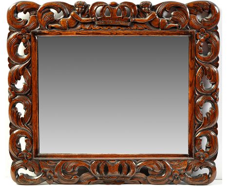 A 19th Century carved oak wall mirror, the rectangular plate within pierced leaf and flowerhead carved frame, with cherubs an