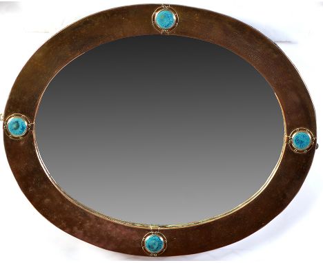 An Arts & Crafts oval wall mirror, the brass-mounted frame inset with turquoise coloured Ruskin type roundel cabochons, 25 x 