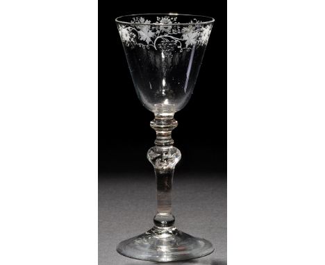A light baluster goblet, the round funnel bowl engraved with a band of flowers and the fruiting vine, raised on a multi-knopp