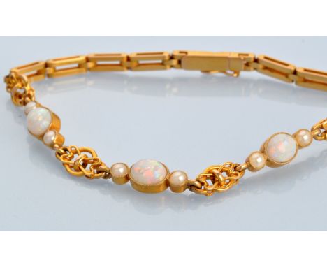 A late 19th Century opal, half pearl and yellow metal bracelet, the three oval opal cabochons flanked by two half pearls, set