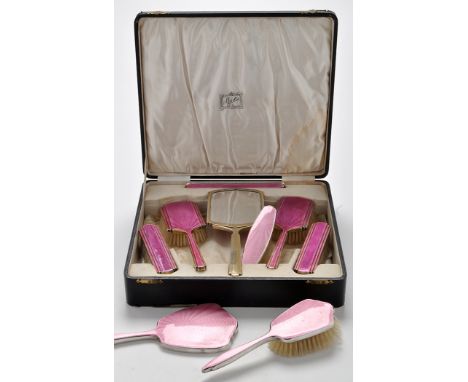 A George V six-piece silver and pink enamel dressing table set, by Henry Clifford Davis, Birmingham 1934, in Reid's velvet li