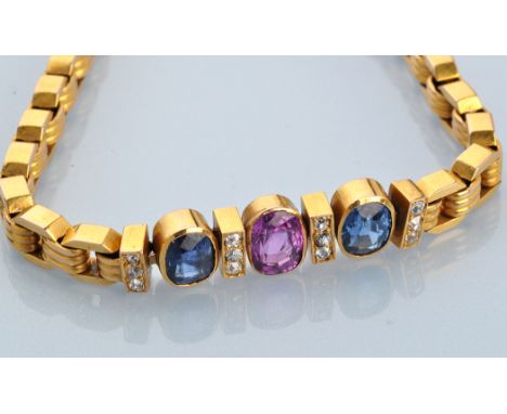 A ruby, sapphire, diamond and yellow metal bracelet, the central oval facet cut ruby flanked by two oval facet cut sapphires,