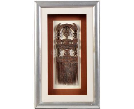 An Ashanti tribe carved wooden comb, c.1930's, Ghana, decorated with a stylized figure and other designs, 16 1/2in. (42cms) h