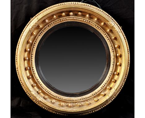 *A Regency giltwood convex wall mirror, the singular plate within ebonised reeded slip, the frame with beadwork, gadrooning, 
