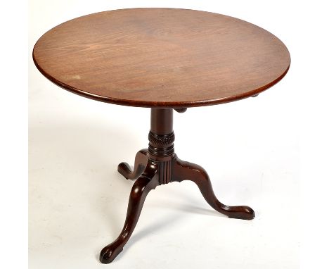 A George III circular mahogany tip-up-top occasional table, raised on a turned column with scrolling tripod legs, 34 1/2 diam