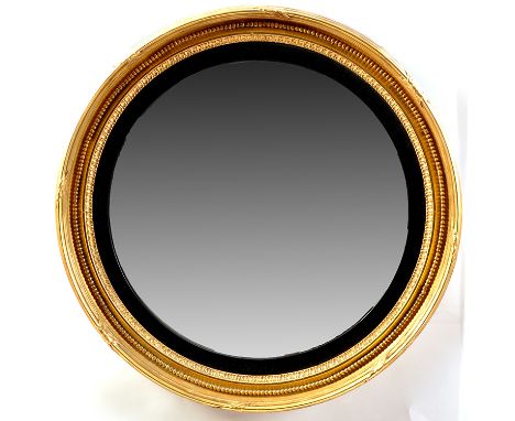 A Regency giltwood convex wall mirror, the plate within ebonised slip, the border with lotiform design, beadwork and applied 