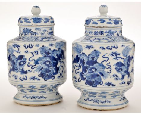 Pair of Chinese blue and white vases and covers, the bodies of cylindrical form with Buddhist lions playing amidst cloud scro