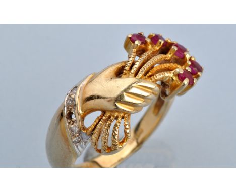 A ruby, diamond and 14ct. yellow gold ring, modelled as a hand holding a bouquet of flowers with ruby set flowerheads and dia